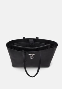 Černá kožená taška přes rameno s dvojitými držadly, vnitřní kapsou na zip a kovovým zapínáním na vnějším povrchu. Viditelné detaily texturovaného povrchu.