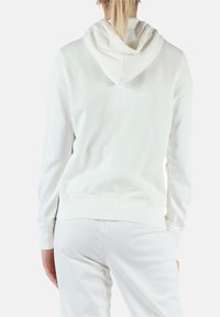 Felpa bianca con cappuccio, caratterizzata da una consistenza morbida, maniche lunghe, polsini a costine e tasca a marsupio. Design minimalista con vestibilità rilassata.