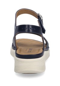 Navy blue sandals with a smooth leather upper and a light-colored, textured rubber sole. Features an adjustable ankle strap for secure fit.