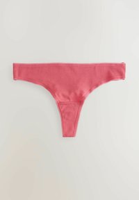 String rose en tissu doux et extensible. Présente une taille fine et des bords festonnés. Design simple sans motifs visibles.