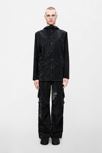 Μαύρο αδιάβροχο μπουφάν με υφή σχεδίασης, συνδυασμένο με χαλαρά παντελόνια σε ταιριαστό σχέδιο. Διαθέτει κουκούλα και κούμπωμα με κουμπιά.