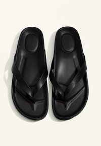 Pantofi flip-flop negri, fabricați dintr-un material sintetic neted, cu o talpă texturată, având două curele late și intersectate pentru o fixare sigură.