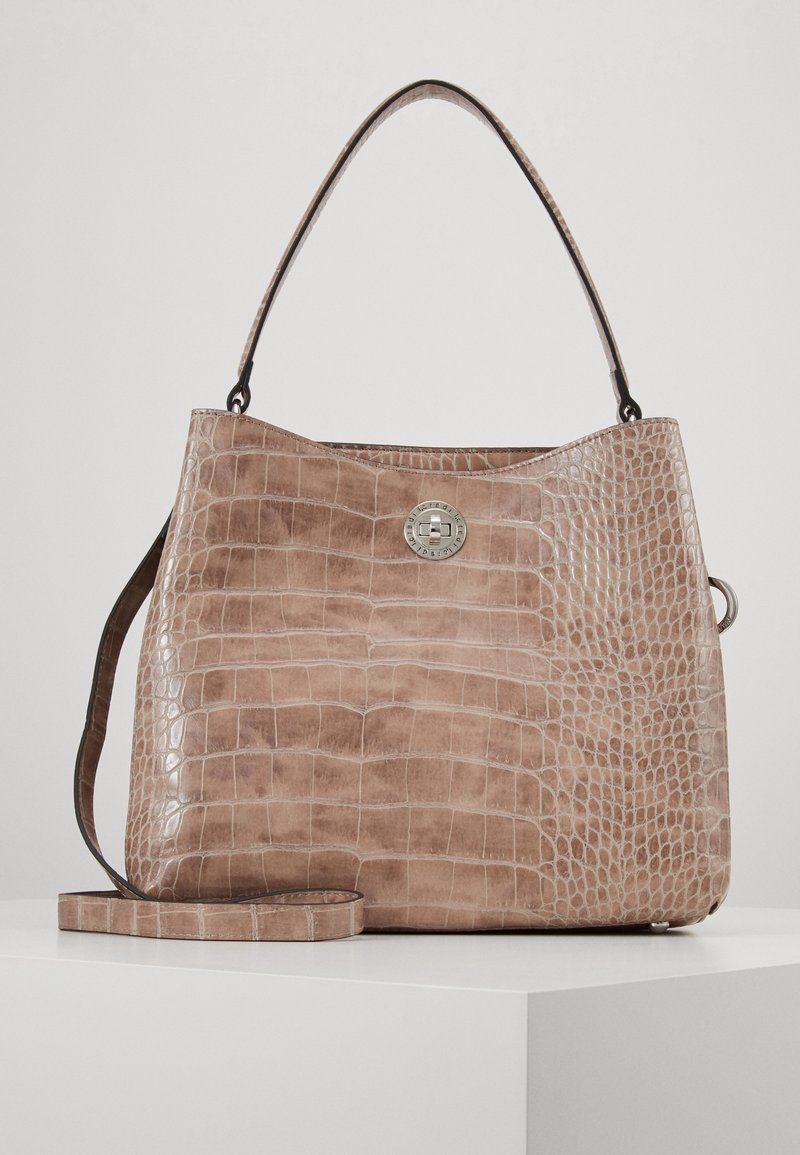 Sac à main en cuir beige à texture crocodile avec poignée supérieure, bandoulière amovible et fermeture frontale circulaire argentée à torsion.