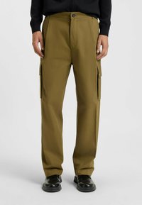 Cargo pants in olive green, featuring a relaxed fit, two side cargo pockets, and a smooth texture. Finished with a button closure.