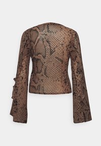 Blusa transparente de mangas longas com padrão de estampado de cobra castanho. Detalhe rufado nos punhos das mangas. Tecido leve com um acabamento texturizado.