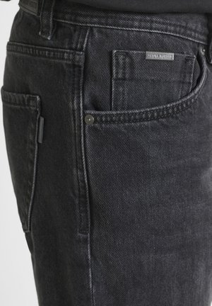 Jeans in denim nero con una texture spazzolata, design classico a cinque tasche e una piccola etichetta con il marchio sulla tasca posteriore.