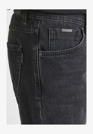 Jeans in denim nero con una texture spazzolata, design classico a cinque tasche e una piccola etichetta con il marchio sulla tasca posteriore.