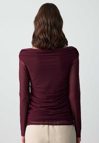 Bordeauxrot Oberteil mit langen Ärmeln, figurbetontem Design, schulterfreiem Ausschnitt, gerafften Details und leichtem, durchscheinendem Material.