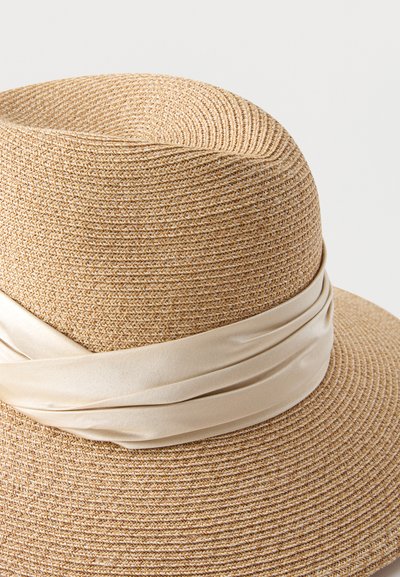 Ψάθινο καπέλο με φαρδύ γείσο και λείο μπεζ υφασμάτινο κορδέλα τυλιγμένη γύρω από τη βάση της κορυφής.