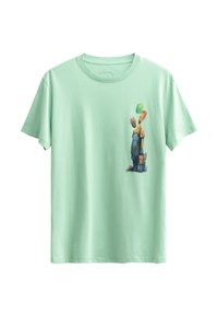 T-shirt en coton vert menthe avec un graphique coloré de deux personnages en salopette, l'un tenant un ballon vert, sur le côté avant gauche.