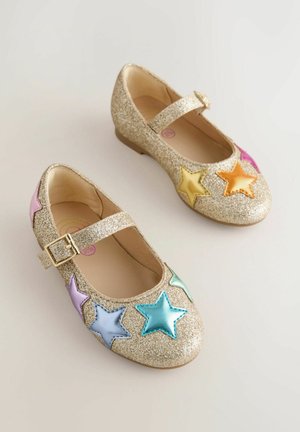 Zelta mirdzoši Mary Jane stila apavi ar siksniņu, uz pirkstu zonas izšūti daudzkrāsaini zvaigžņu akcenti rozā, zilā, zaļā, dzeltenā un oranžā krāsā.