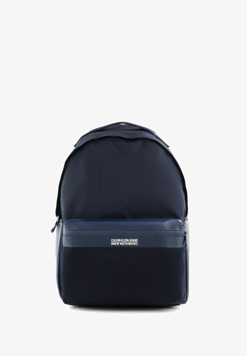 Sac à dos bleu marine avec un corps en tissu tissé, des accents lisses et un panneau inférieur texturé ; comprend une poche avant zippée et un détail logo.