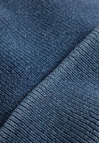 Blue fabric with a ribbed texture, featuring a medium-weight knit. Two sections overlap, showcasing varying shades of blue and subtle variations in thread.
