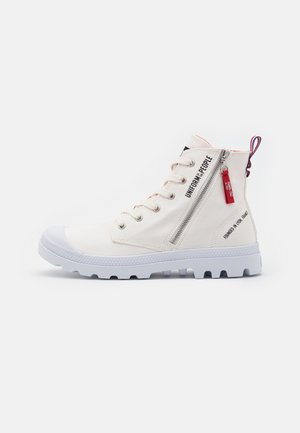 Høje sneakers i off-white canvas med en hvid gummitåhætte og en robust sål. Har en sidelukning med lynlås og trykt brandingdetalje.