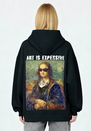 Felpa nera oversize con grafica della Gioconda che indossa occhiali da sole, con il testo "L'ARTE È COSTOSA" sopra l'immagine.