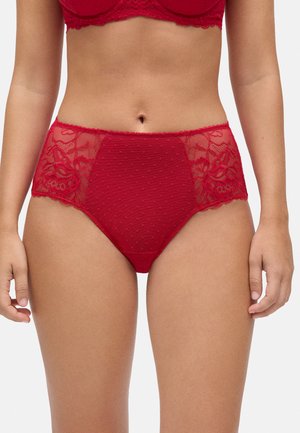 Bragas rojas de talle alto con un patrón de lunares, detalles de encaje y bordes ondulados en la cinturilla y las piernas.