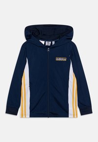 Sudadera con cremallera en color navy, con capucha, franjas laterales en blanco y amarillo, y un parche del logo de Adidas en el pecho. Tejido suave, diseño deportivo.