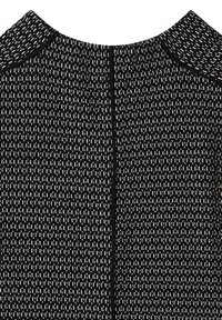 Černé šaty s texturovaným vzorem malých bílých vertikálních pruhů, s kulatým výstřihem a skrytým zipem na zadní straně.