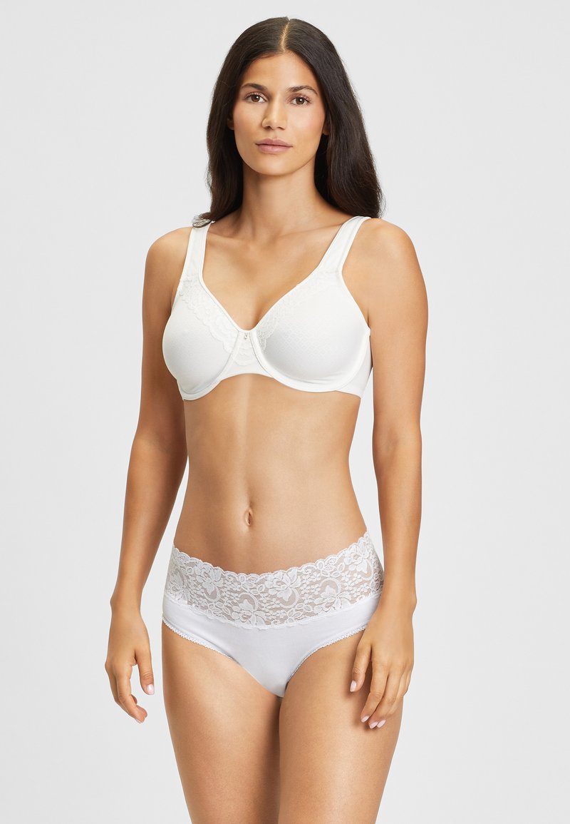 Soutien-gorge blanc à dentelle avec des bonnets texturés et de larges bretelles, assorti avec un slip blanc comportant une taille en dentelle florale.