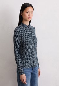 Langärmeliges Hemd in Marineblau mit geometrischem Blumenmuster in Hellblau. Verfügt über einen Kragen und weichen Stoff.