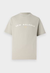 Gaiši pelēks kokvilnas T-krekls ar vēlmes izgriezumu. Iespējams "NEW BALANCE" teksts baltā un zelta krāsā, īsas piedurknes un brīvs piegriezums.