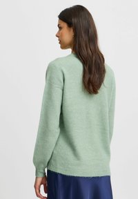 Mintgrüner Pullover aus weichem, strukturiertem Strick. Mit Rundhalsausschnitt und langen Ärmeln, leicht lockerer Passform und geradem Saum.
