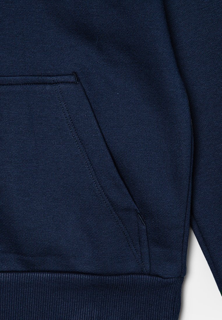 Navyblauer Sweatshirt mit Kängurutasche, gerippten Bündchen und Saum, hergestellt aus strukturiertem Stoff mit sichtbaren Nähten.