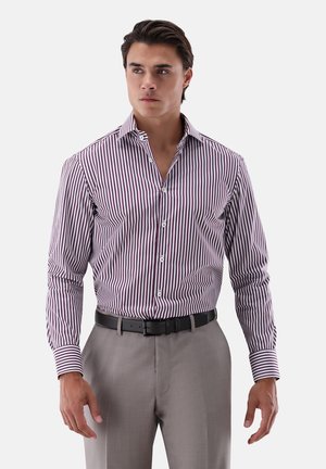 Herren Langarmhemd in Weiß mit schmalen weinroten Streifen, Button-Down-Kragen und tailliertem Schnitt, kombiniert mit grauen Hosen und einem schwarzen Gürtel.