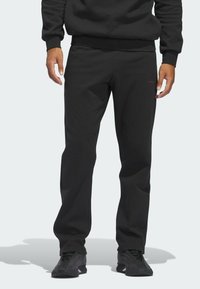 Zwarte sweatpants met een lose pasvorm, gemaakt van zacht materiaal. Voorzien van een elastische tailleband en een minimale rode logo-accent op het been.