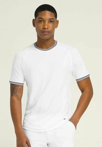 Camiseta blanca de manga corta con cuello redondo y detalles a rayas en azul marino en el cuello y las mangas. Tejido suave, diseño ajustado.