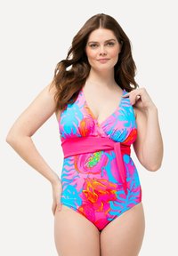 Maillot de bain une pièce en rose vif, avec de grands motifs tropicaux bleus et oranges. Le design comprend une taille enveloppante et un décolleté en V profond.