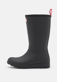 Botte de pluie en caoutchouc noir avec un orteil rond, une surface texturée et une languette rouge. Dispose d'une semelle plate et d'une couture sur le côté.