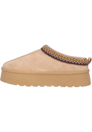 Beige slip-on sko med tekstureret stof, en tyk tan sål, og dekorativ brun og gul syning omkring kraven.