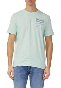 Licht muntgroen T-shirt met een ronde hals, korte mouwen en blauw gedrukt tekst in de linkerbovenhoek. Zachte textuur, casual pasvorm.
