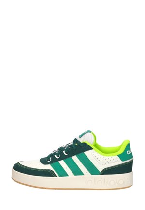 Baskets basses Adidas blanches et vertes avec trois bandes vertes, accents vert foncé, doublure vert néon et semelle blanche.