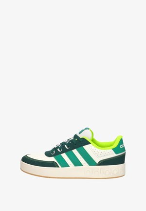Baskets basses Adidas blanches et vertes avec trois bandes vertes, accents vert foncé, doublure vert néon et semelle blanche.