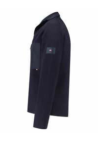 Veste à manches longues bleu marine avec poche zippée sur la poitrine et petit logo sur la manche supérieure.