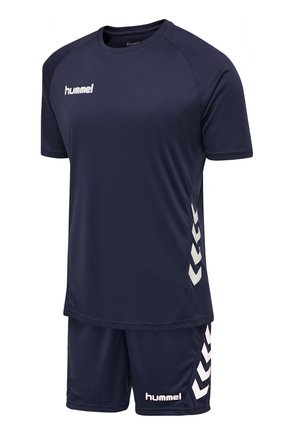 Marineblauw sportoutfit met korte mouwen en bijpassende shorts. Bevat een wit logo en chevronpatronen aan de zijkanten. Gemaakt van ademend materiaal.