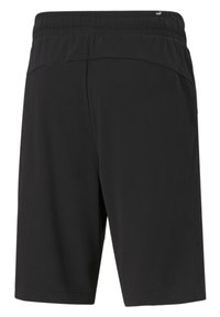 Mustat shortsit, joissa on joustava vyötärö, sileä kangas, polven pituinen ja ilman näkyviä kuvioita tai yksityiskohtia. Näkymä takaa.