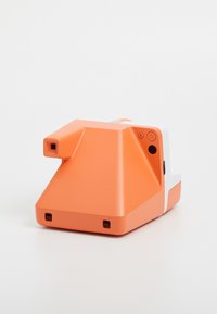 Orange camera with a triangular shape and white accents. Features a lens, buttons, and a slot for film. Smooth plastic texture.