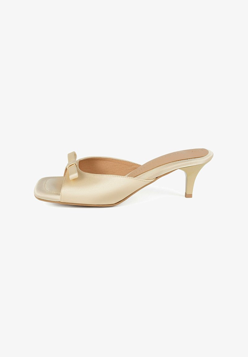 Beige Satin Slingback-Sandal mit offener Zehenpartie und quadratischer Zehenform, kleinen Schleifenakzenten an der Vorderseite sowie einem schlanken, leicht gebogenen Absatz. Flache Laufsohle.