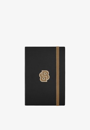Czarny, zamknięty notes z beżową elastyczną opaską i beżowym stylizowanym logo "B" wyśrodkowanym na przedniej okładce na białym tle.