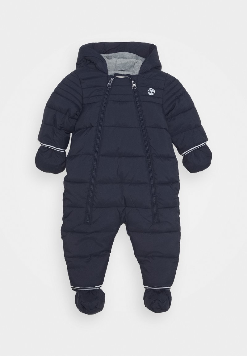 Combinaison de neige bleu marine à capuche pour bébé avec moufles et chaussons rembourrés, double fermeture éclair devant et petit logo blanc sur la poitrine.