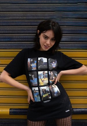 Zwart oversized T-shirt met een collage van foto's in een rasterpatroon. Het materiaal is katoen, met een gladde textuur en een ronde hals.