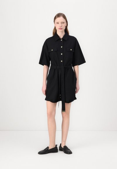 Robe noire à manches courtes avec un col, un devant à boutons, deux poches poitrine, une taille cintrée avec une ceinture et une texture de tissu lisse.