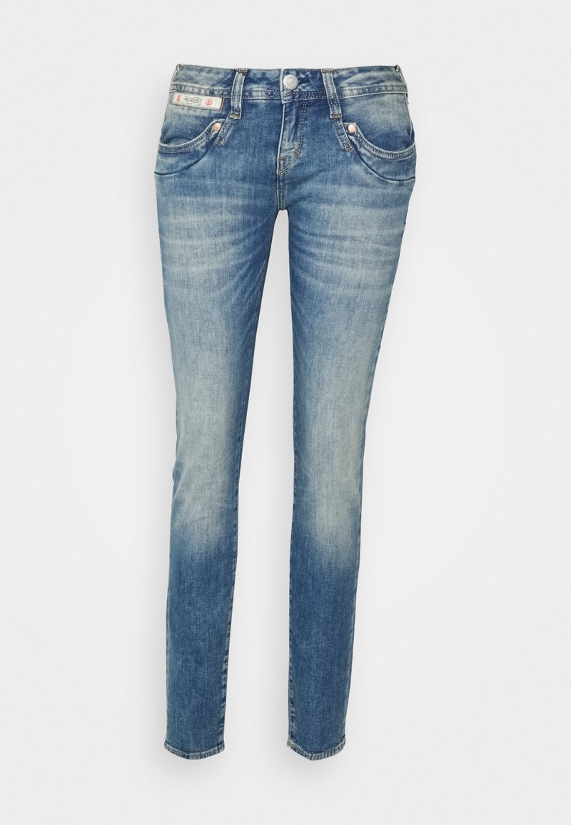 Jean slim bleu délavé avec poches avant, passants pour ceinture et fermeture par bouton, présenté sur un fond blanc uni.