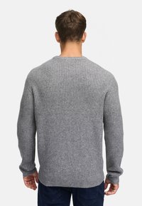 Grå ribbet sweater med rund halsudskæring, lange ærmer og en afslappet pasform. Den strukturerede strik kontrastrerer med det glatte stof på ryggen.