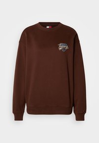 Sudadera marrón con un cuello redondo clásico, puños y dobladillo acanalados, que presenta un logo "Tommy" multicolor bordado en el pecho.