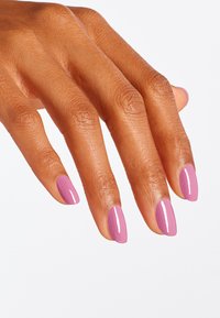 Bruine hand met lange, amandelvormige nagels, gelakt in glanzend pastelroze. Huidtextuur zichtbaar, met natuurlijke lijnen en details.