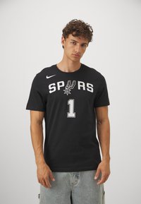 Sort bomulds t-shirt med "SPURS" i fed hvid skrift, nummer "1" nedenfor og Nike-logo. Kortærmet og med rund hals.